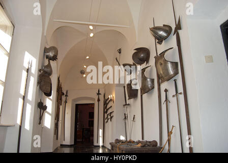 Caschi medievale, corazza, spade, pistole e alabarde come decorazione nella parte interna di un vecchio maniero o il museo del castello. Schloss Ottersbach, Austria. Foto Stock