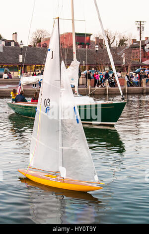 Un telecomando barca a vela modello vele accanto a una vera e propria barca a vela vicino alla città di Dock in Annapolis, Maryland. Foto Stock