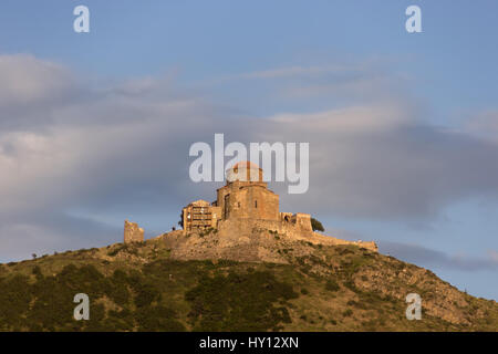 Mtskheta, Georgia. Il mondo antico patrimonio, Ortodossa Georgiana Monastero Jvari sulla molla verde valle, panoramiche Montagne Colline, cielo nuvoloso Backgro Foto Stock