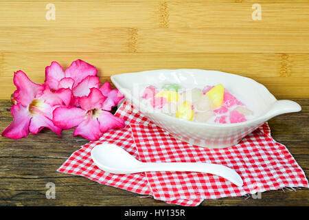 Croccante di acqua le castagne in crema di noce di cocco con cucchiaio e fiore Foto Stock