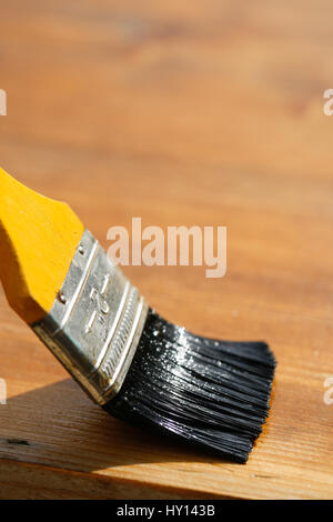 Pennello scorrimento su una superficie di legno, la protezione del legno per influenze esteriori, agenti atmosferici, insetti e funghi. Carpenteria in legno, home improvement Foto Stock