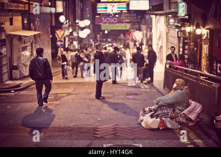 Una persona senza dimora è per l'accattonaggio denaro su una strada di Hong Kong, Cina. Molte persone senza dimora non sono neanche a guadagnare abbastanza per un piatto suddiviso. Foto Stock