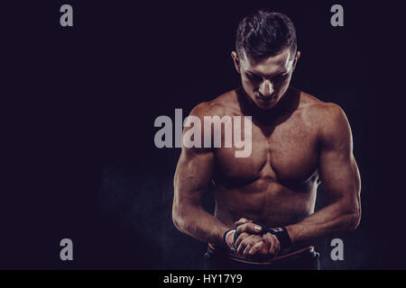 MMA Fighter Preparazione di bendaggi per la formazione. Sfondo scuro. Foto Stock