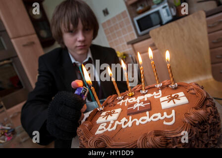 Quattordici anni ragazzo di compleanno con torta e candele. Foto Stock