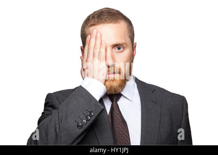 Ritratto di imprenditore bello che copre un occhio con la sua mano come egli guarda direttamente la fotocamera. isolato su sfondo bianco. Foto Stock
