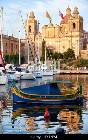 Il tradizionale maltese Luzzu barche e yacht ormeggiati nel porto di Dockyard Creek nella parte anteriore della chiesa di San Lorenzo, Birgu, Malta Foto Stock