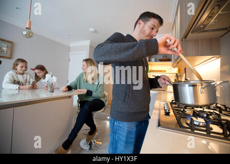 Famiglia britannica utilizzando utilità di gas a casa Foto Stock