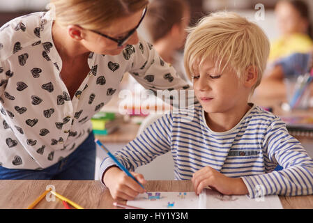 Insegnante facendo attenzione su little boy Foto Stock