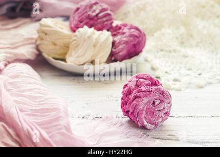 Zephyr (Russo marshmallow) luce sul tavolo di legno decorato con panno rosa e pizzo bianco Foto Stock