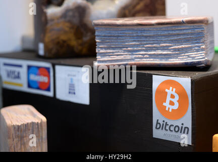 Leipzig, Germania. 24 Mar, 2017. Un segno indica che bitcoin è accettato come mezzo di pagamento presso lo stand di un espositore alla fiera del libro di Lipsia, Germania, 24 marzo 2017. In questo caso particolare, bitcoin è accettato come mezzo di pagamento per i libri fatti in pietra. Foto: Jens Kalaene/dpa-Zentralbild/ZB/dpa/Alamy Live News Foto Stock