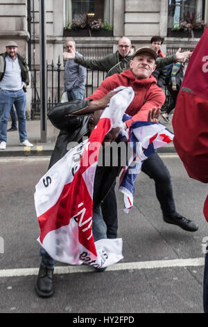 Londra, Regno Unito. Il 1 aprile, 2017. Un anti-fascista viene attaccato violentemente mentre si tenta di prendere una bandiera nazionalista da un'estrema destra EDL stati(rosso in alto) durante un contatore-protestare contro di estrema destra gruppi marciando attraverso Westminster. © Guy Corbishley/Alamy Live News Foto Stock