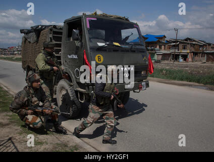 (170401) -- SRINAGAR, 1 aprile 2017 (Xinhua) -- esercito indiano troopers prendere posizione in prossimità di un esercito danneggiato il carrello dopo essere aggredito da militanti a Bemina tangenziale sulla periferia di Srinagar city, la capitale estiva di Indiano-Kashmir controllata, 1 aprile 2017. Almeno quattro esercito indiano troopers sono stati feriti sabato dopo i militanti hanno attaccato un esercito indiano in covey irrequieta indiano-Kashmir controllata, hanno detto i funzionari. (Xinhua/Javed Dar) (ZF) Foto Stock