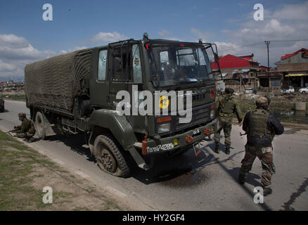 (170401) -- SRINAGAR, 1 aprile 2017 (Xinhua) -- esercito indiano troopers prendere posizione in prossimità di un esercito danneggiato il carrello dopo essere aggredito da militanti a Bemina tangenziale sulla periferia di Srinagar city, la capitale estiva di Indiano-Kashmir controllata, 1 aprile 2017. Almeno quattro esercito indiano troopers sono stati feriti sabato dopo i militanti hanno attaccato un esercito indiano in covey irrequieta indiano-Kashmir controllata, hanno detto i funzionari. (Xinhua/Javed Dar) (ZF) Foto Stock