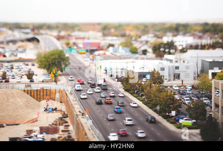 Tilt-lente colpo di Boise, Idaho, Stati Uniti d'America su un estate o in autunno il giorno. Automobili nel traffico sulla strada principale tra la zona di costruzione e il centro cittadino di edifici. Foto Stock