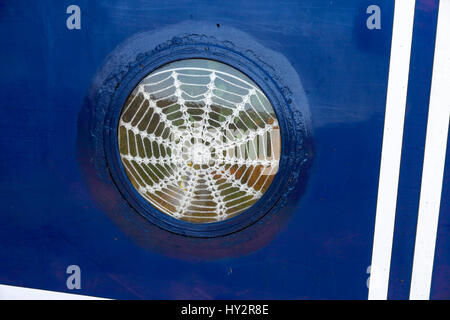 Una tendina di rete realizzato da stringa a forma di spider web in una finestra narrowboat Foto Stock