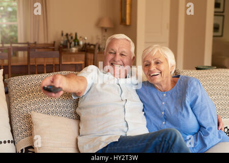 Ridendo coppia senior di guardare la televisione a casa Foto Stock