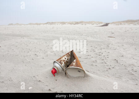 Un vecchio arrugginito in alluminio spray aerosol può sovraccaricare una spiaggia sabbiosa del paesaggio. Foto Stock