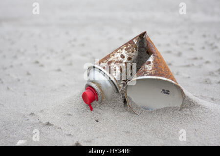 Un vecchio arrugginito in alluminio spray aerosol può sovraccaricare una spiaggia sabbiosa del paesaggio. Foto Stock