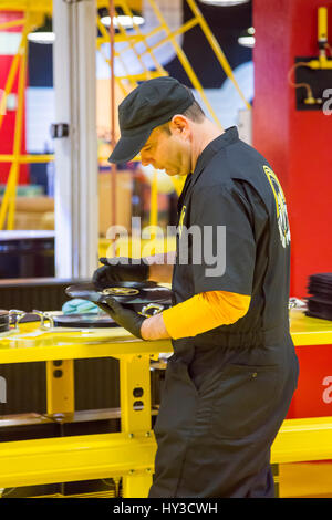 Detroit, Michigan - un lavoratore ispeziona appena premuto dischi in vinile al terzo uomo Records' record-impianto di compressione. Foto Stock