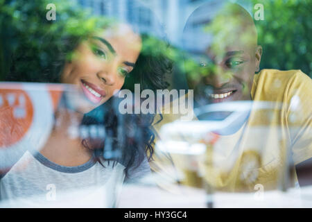 Sorridente coppia giovane nel coffee shop visto attraverso la finestra Foto Stock