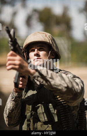 Militare mirando con un fucile in boot camp Foto Stock