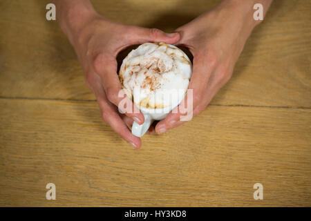 Tettuccio di tiro dell'uomo mani tazza da caffè a tavola in caffetteria Foto Stock