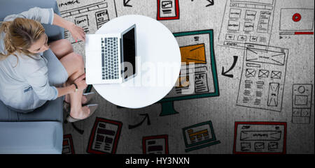 Donna sul suo computer portatile contro la superficie spiovente Foto Stock