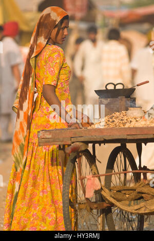 Donna indiana vendendo tostate da un carrello all'annuale Fiera del cammello di Pushkar, Rajasthan, India. Foto Stock