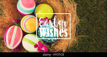 Saluto pasquale contro il dipinto di uova di pasqua nel nido Foto Stock