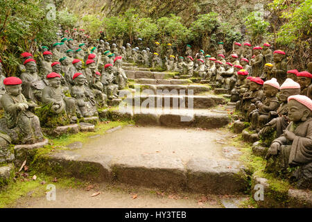 Jizo statue con colorati lavorati a maglia cappelli sedersi su entrambi i lati dei gradini di pietra in Daisho-nel tempio di Miyajima, Giappone Foto Stock