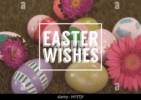Saluto pasquale contro il dipinto di uova di pasqua con fiore di erba Foto Stock