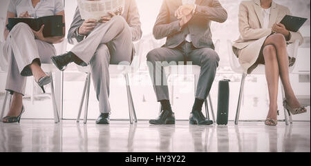 Sala di attesa con business persone sedute in linea in corridoio Foto Stock