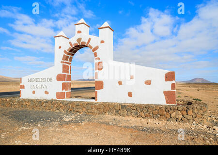 Tipico segno comune (bianco arch gate) in La Oliva villaggio con il paesaggio del deserto in background, Fuerteventura, Isole Canarie, Spagna Foto Stock