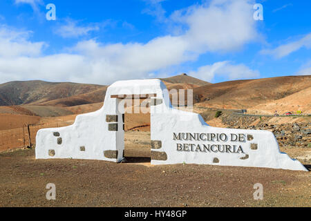 Comune tradizionale segno (bianco arch gate) vicino al villaggio di Betancuria con il paesaggio del deserto in background, Fuerteventura, Isole Canarie, Spagna Foto Stock