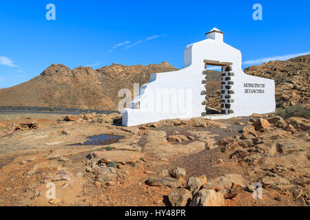 Comune tradizionale segno (bianco arch gate) vicino al villaggio di Betancuria con il paesaggio del deserto in background, Fuerteventura, Isole Canarie, Spagna Foto Stock