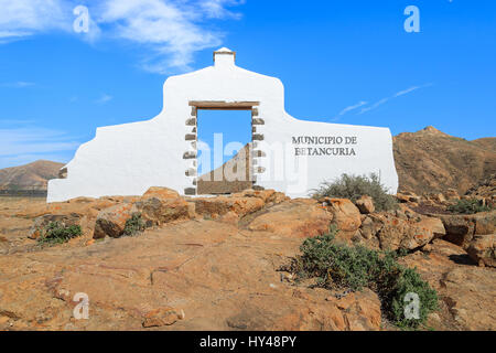 Comune tradizionale segno (bianco arch gate) vicino al villaggio di Betancuria con il paesaggio del deserto in background, Fuerteventura, Isole Canarie, Spagna Foto Stock