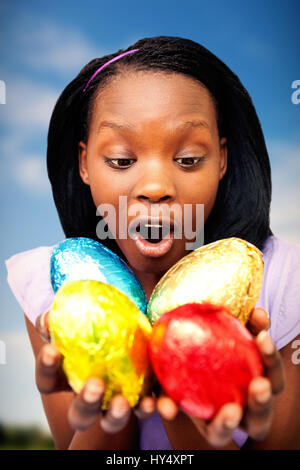 Campagna contro la donna allegra holding colorate uova di pasqua Foto Stock