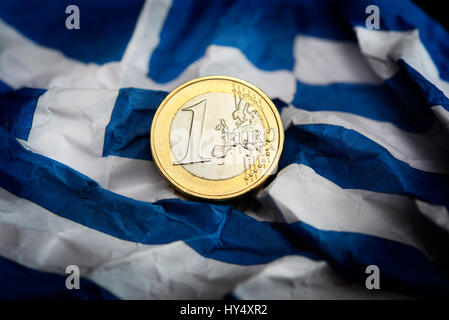 Eurocoin accartocciata sulla bandiera della Grecia, simbolico debito foto litigio, Euromuenze auf zerknitterter Griechenlandfahne, Symbolfoto Schuldenstreit Foto Stock