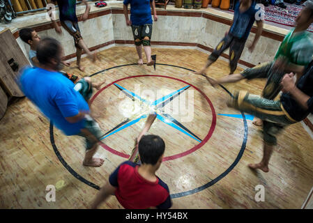 Iraniane di uomini e ragazzi nella formazione Zoorkhaneh (casa di forza), tradizionale palestra in Yazd, la capitale della provincia di Yazd dell'Iran Foto Stock