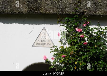 Cottages intorno al verde. Ardeley, Hertfordshire,con la scritta "Auspicium Melioris Aevis", che significa "un segno dei tempi migliori" Foto Stock