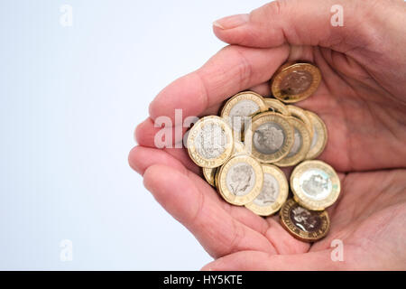 Azienda pound monete nel palmo della mano Foto Stock