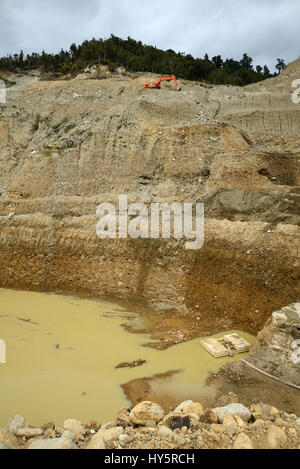 Un gold miner strisce sovraccaricare da una miniera a cielo aperto per raggiungere la più scura paydirt qui di seguito Foto Stock