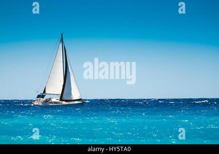 White in barca a vela in aprire il mare blu in Grecia Foto Stock
