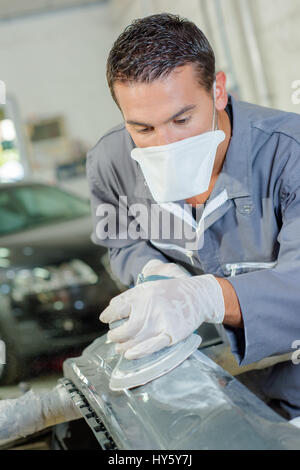 Lavoratore in auto officina carrozzeria Foto Stock