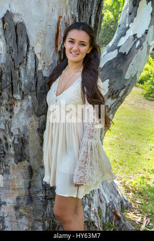 Diciottenne ragazza in piedi da un albero, La Jolla, California Foto Stock