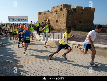 Gli atleti di lasciare l'inizio del 4k la gara su strada nella parte anteriore del Castello di Pafo, porto di Paphos, Cipro. Foto Stock