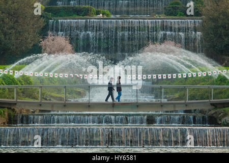 Roma, Italia - 10 Aprile 2011: non identificato due giovani uomini a camminare nel Laghetto Eur Parco, di fronte alle principali fontana a cascata. Questo luogo è anche cal Foto Stock