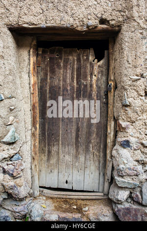 Vecchia porta di legno nella casa di pietra Foto Stock