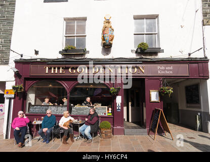 La gente seduta al di fuori del Golden Lion pub in Keswick, Cumbria, England, Regno Unito Foto Stock