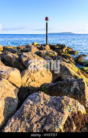 Una spia rossa marcatore sul promontorio roccioso a Ringstead Bay, Dorset, England, Regno Unito Foto Stock